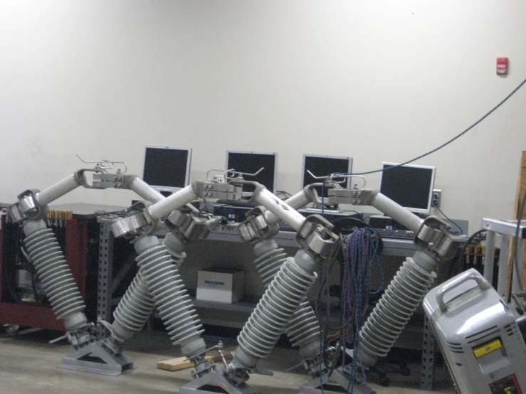 several robot arms working on a wall in a workshop