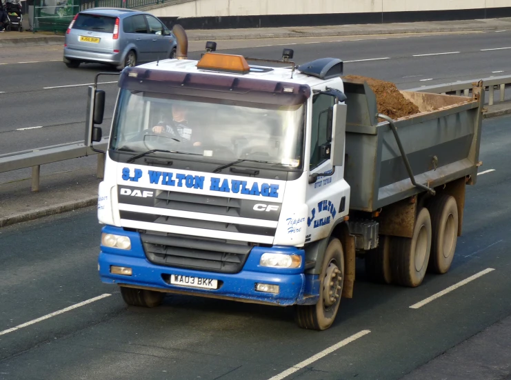 a blue and white truck is on the road