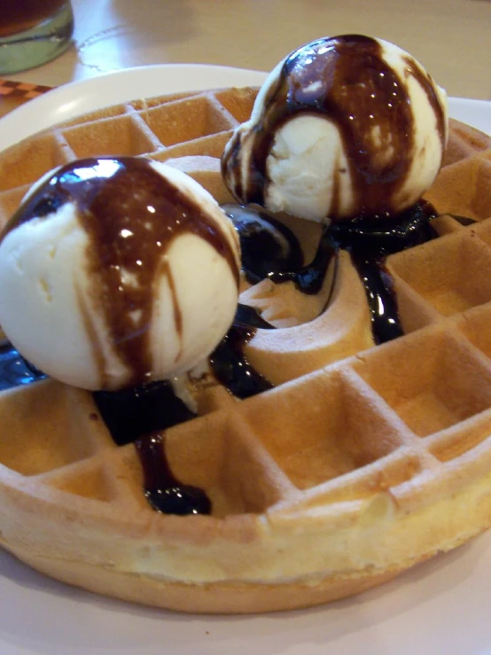 two scoops of ice cream sitting on top of a waffle