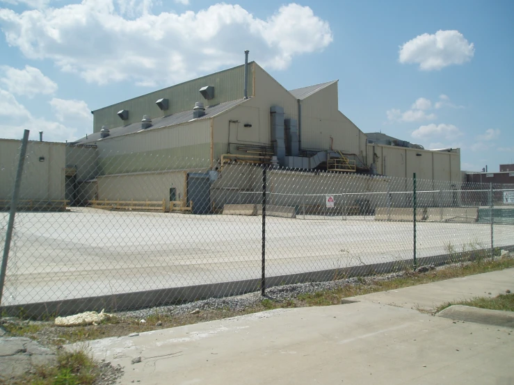 a large warehouse with a fence around it