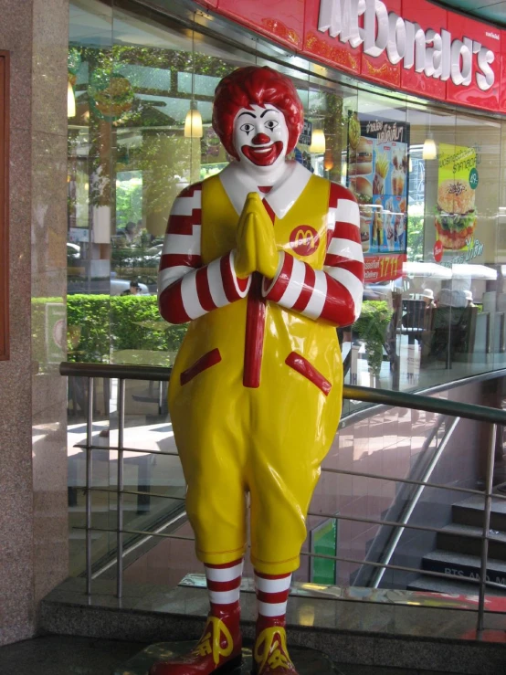 a large statue of a clown wearing a striped outfit