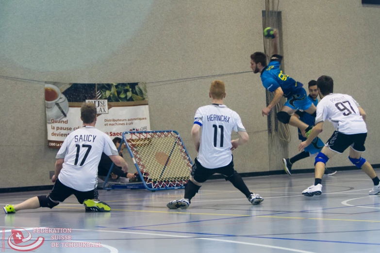 a group of young men play soccer in a gym