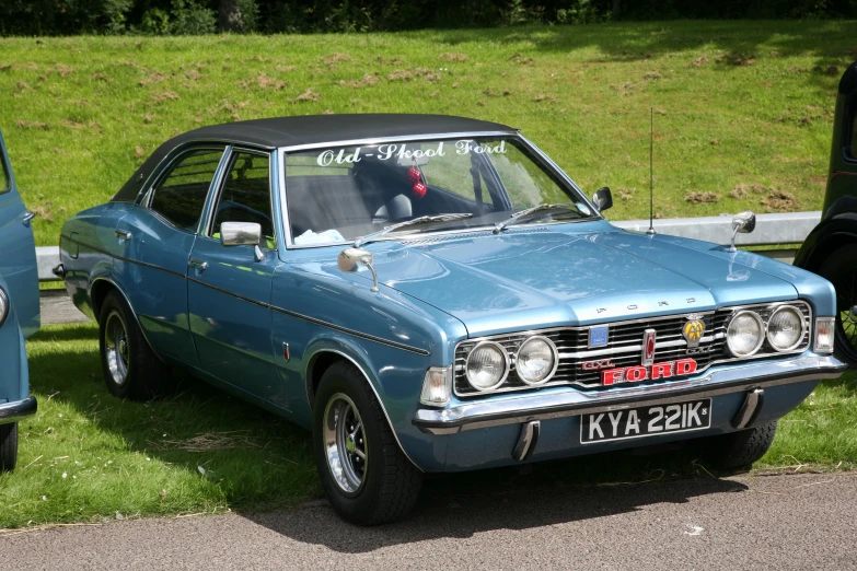 an old blue station wagon is parked next to another old model car