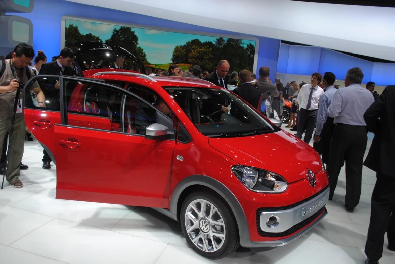 a red car sits on display at a show