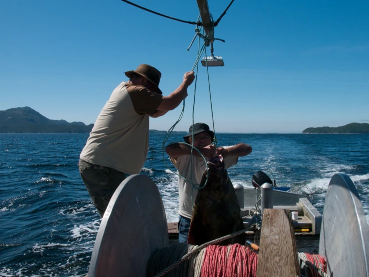 some people and a black dog on the back of a boat