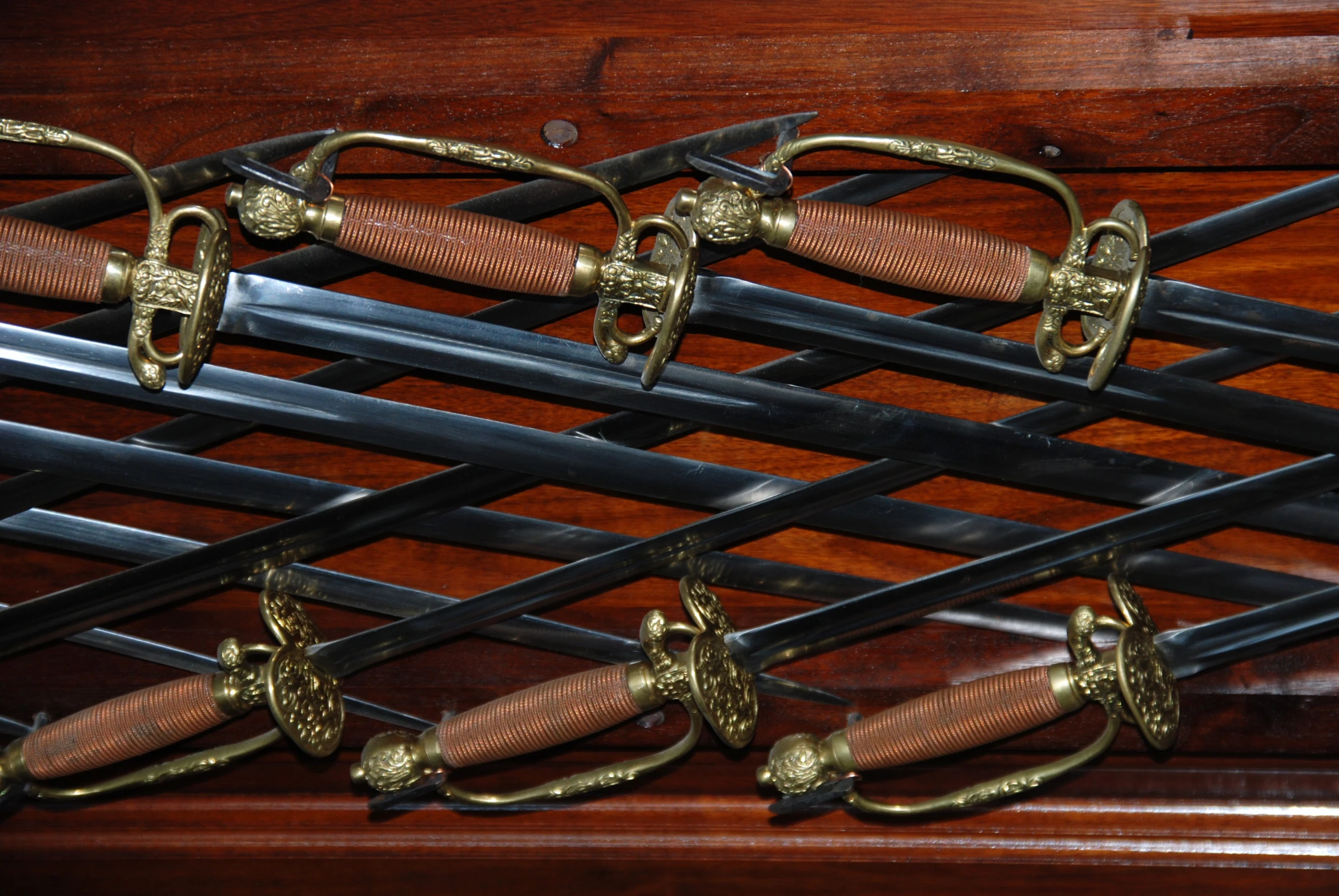 the handle of two antique wooden swords are mounted on a rack