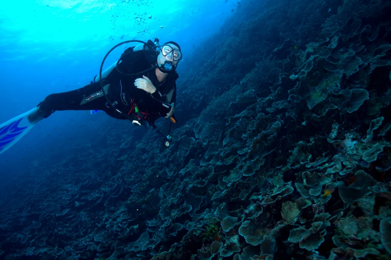 a diver in the water with a large piece of rock
