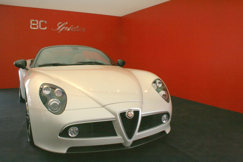 a white convertible sports car sitting in a showroom