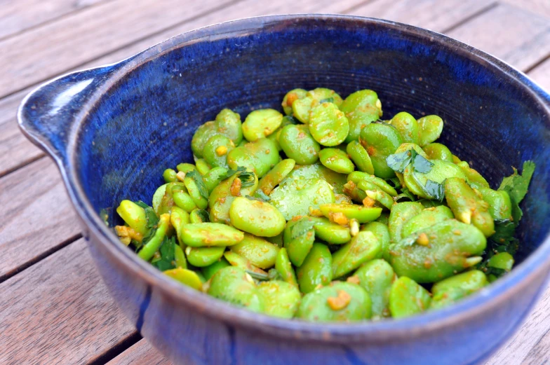 a bowl full of tiny green vegetables and other food