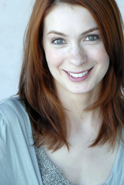 a young woman smiles with her teeth straight ahead