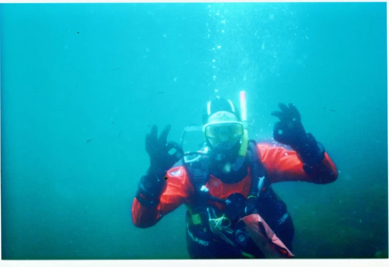 a man diving under water wearing a full diving gear