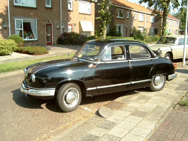 an old car is parked outside of a house