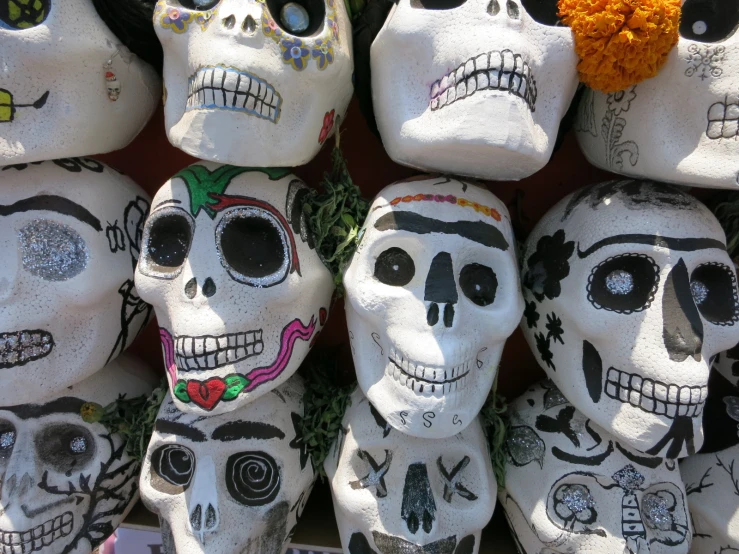 skulls painted in various colors and designs of day of the dead