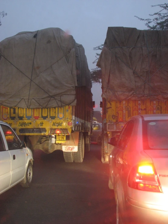 a white car and a large truck on the road