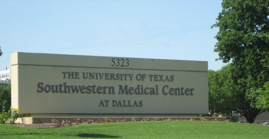 a building sign in front of a green field