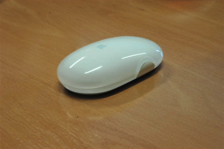 the apple mouse is placed on a wood surface
