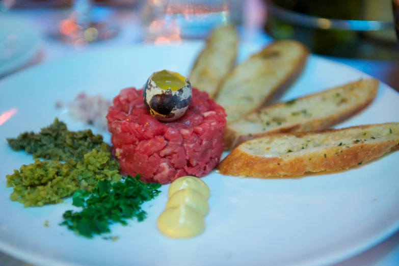 a white plate topped with meat and bread