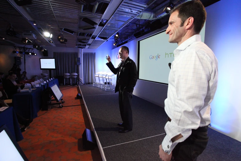 two men standing in a room holding nintendo wii controllers