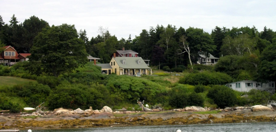 a boat in the water near small buildings on a hill