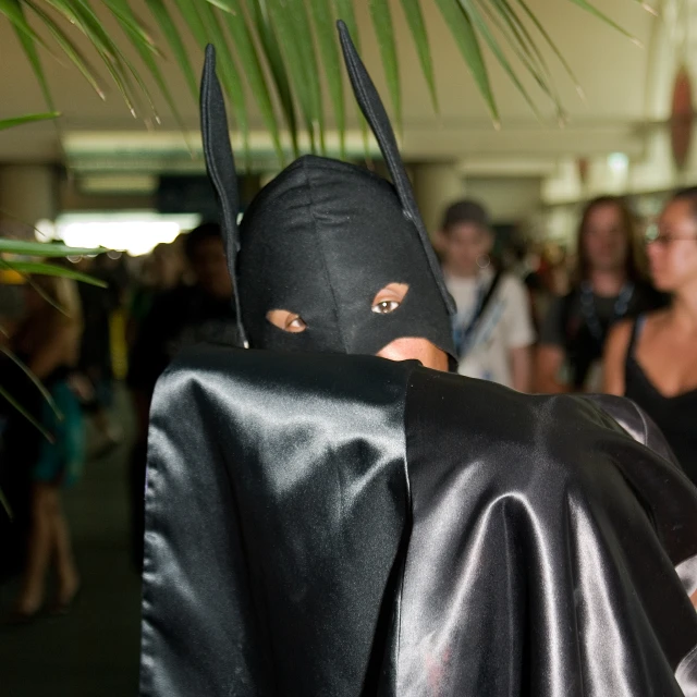 a woman in a cape walking down a hallway