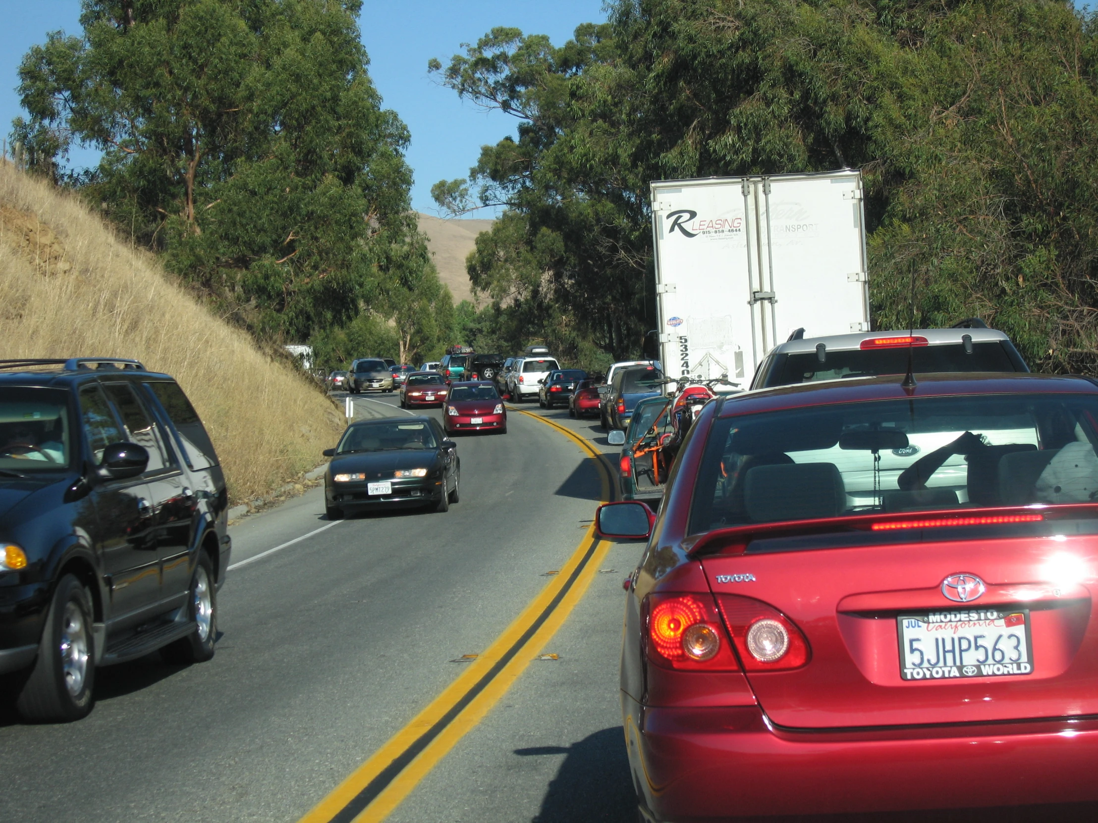 there are cars, trucks and other cars travelling on the road