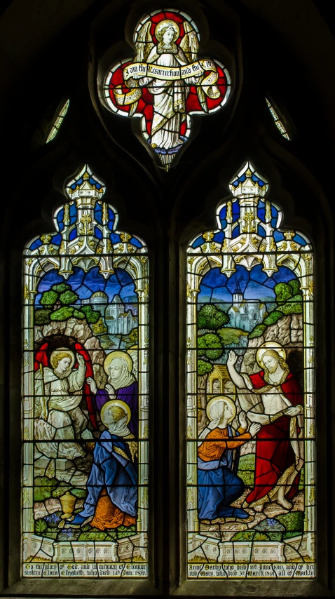 a stained glass window depicting the adoration of the crucifix