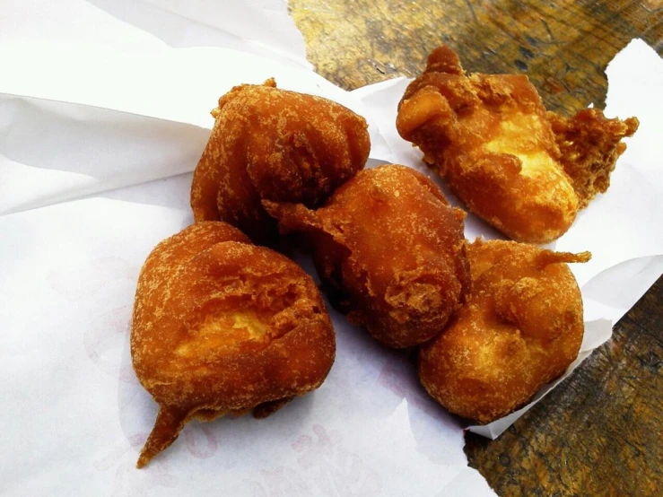 three pieces of fried food sitting on a piece of wax paper