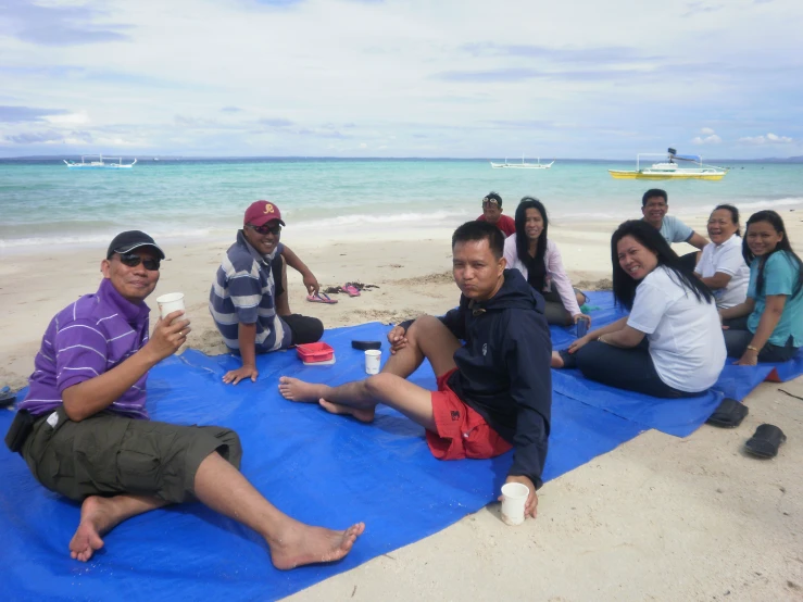 a group of people are on the beach posing for a po