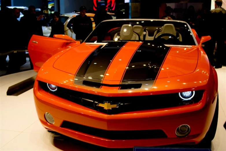 an orange sports car that is on display