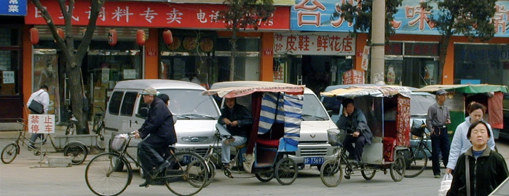 people are walking around with umbrellas and rickshaws