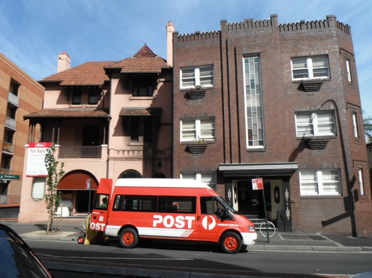 a red and white bus parked near a building