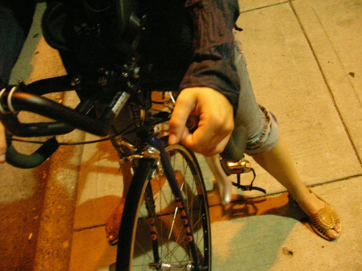 a woman standing near a bicycle with her foot resting on the ground