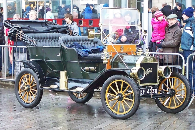 an old fashioned car is parked in the street