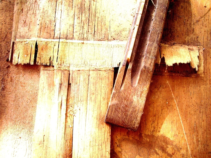 an old and worn wooden door with torn paint on it