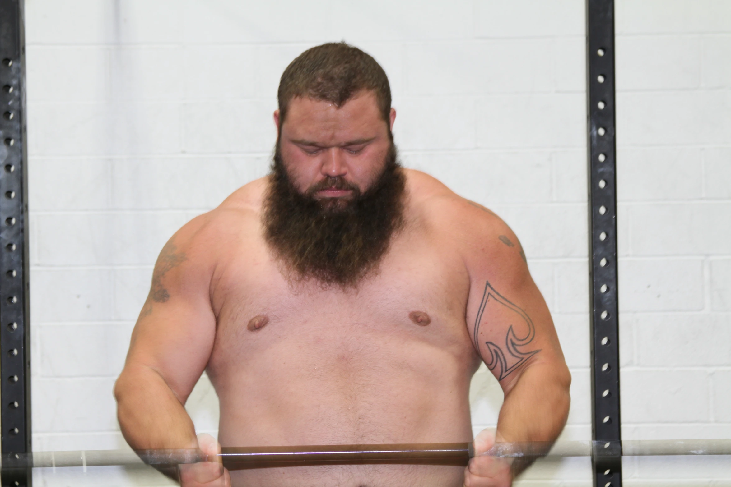 a man with a beard holding an object and a metal bar