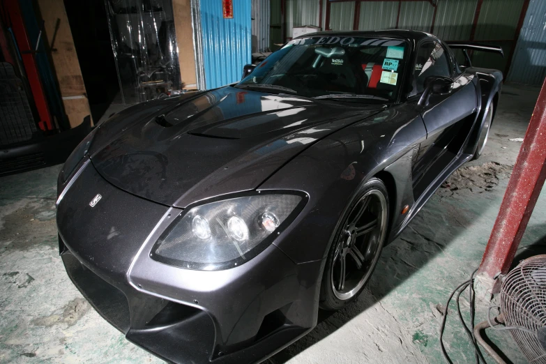 a gray sports car parked in front of a building