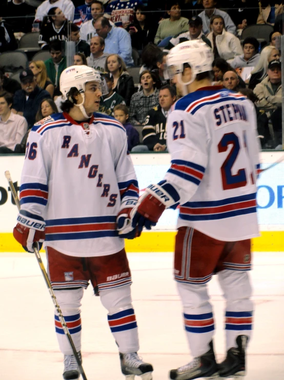 two hockey players are standing on the ice while fans watch