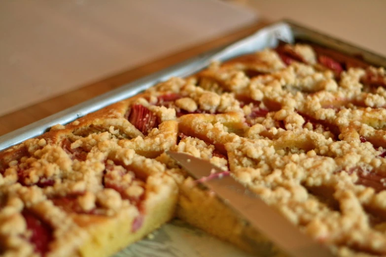 an apple crumb tart is cut from a cake