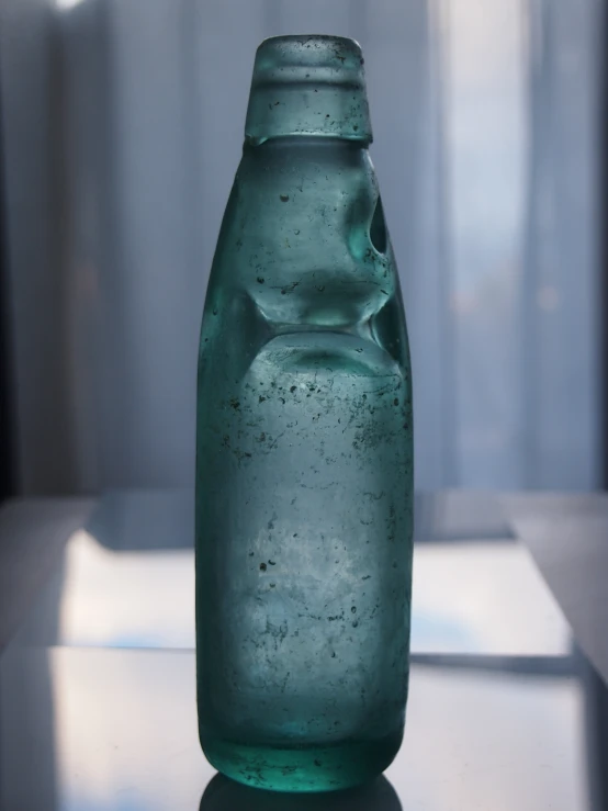 a green bottle sitting on a counter top