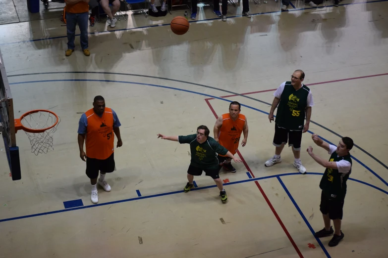 group of men wearing orange shirts standing on basketball court