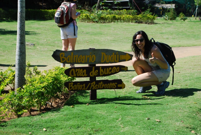 woman posing in front of a wooden sign