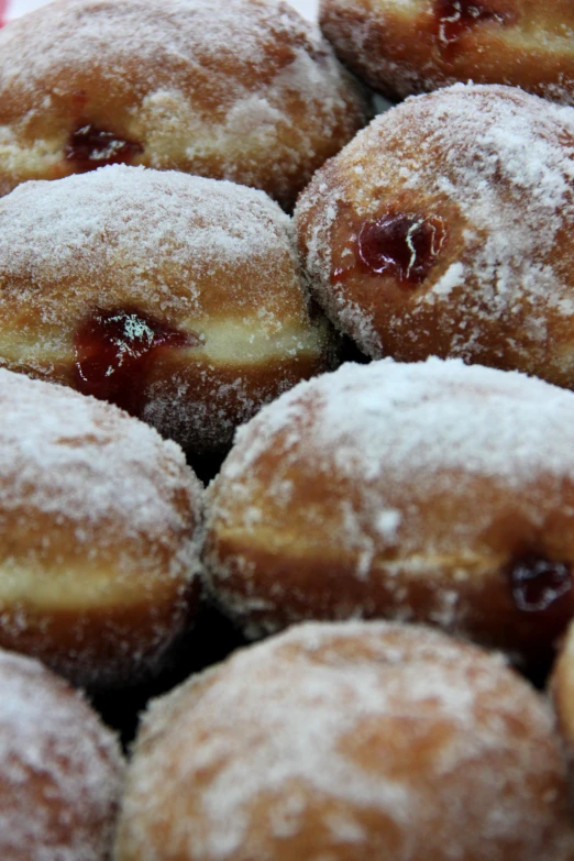 powdered donuts with cherries are piled together