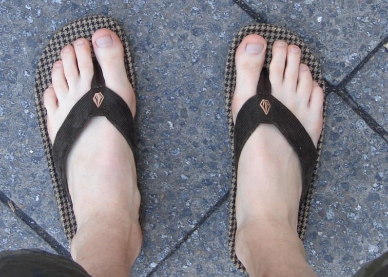 a man is wearing sandals with a cross section on it