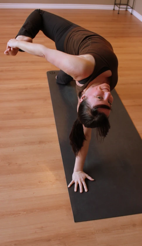 a woman does handstand on top of a mat