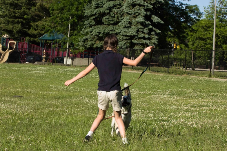 a man with a dog playing frisbee in a field