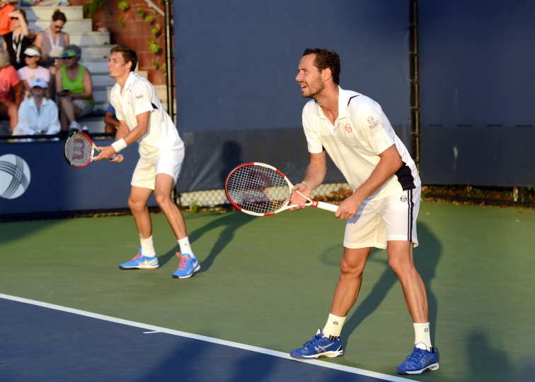 two tennis players standing on a court with rackets