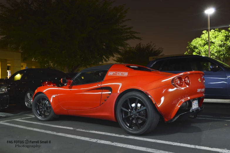 a very bright orange sports car parked in a parking lot