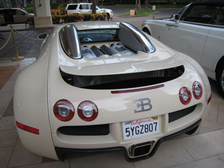 a white sports car parked next to another white car