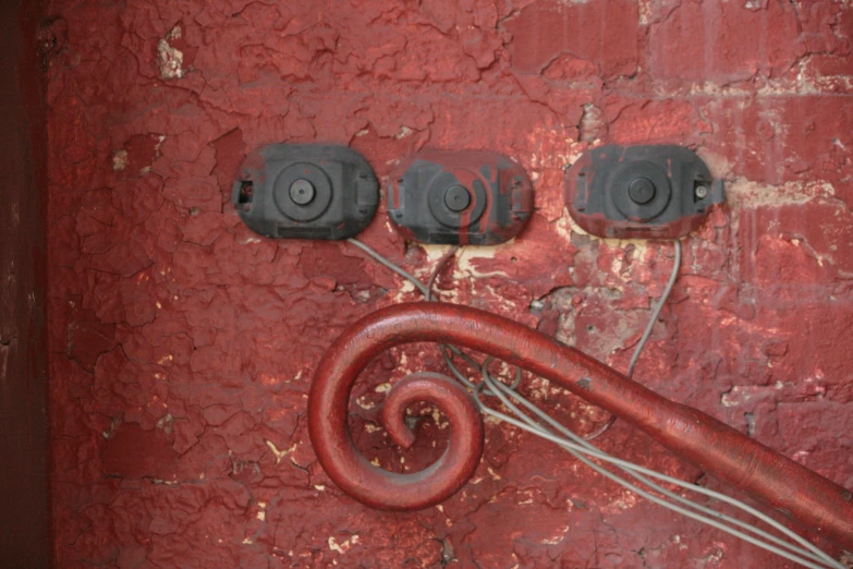 three red cords are hooked up in a rusty area