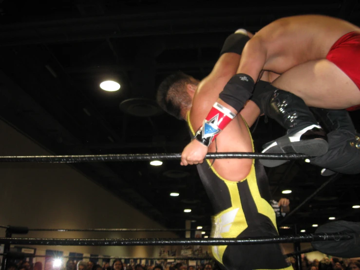 a wrestling match with two men, one in the air